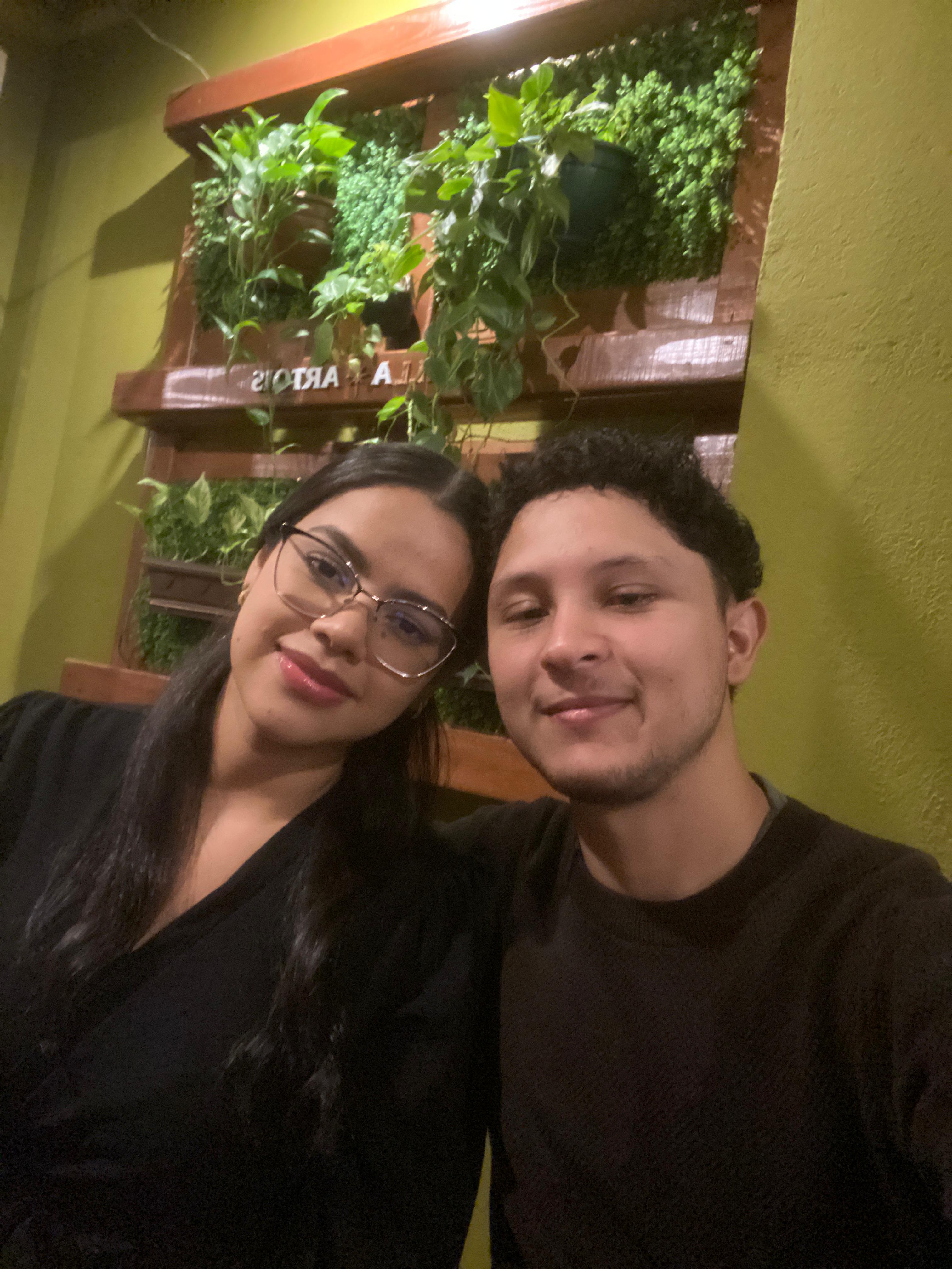 Andressa e Matheus juntos em um ambiente cheio de plantas