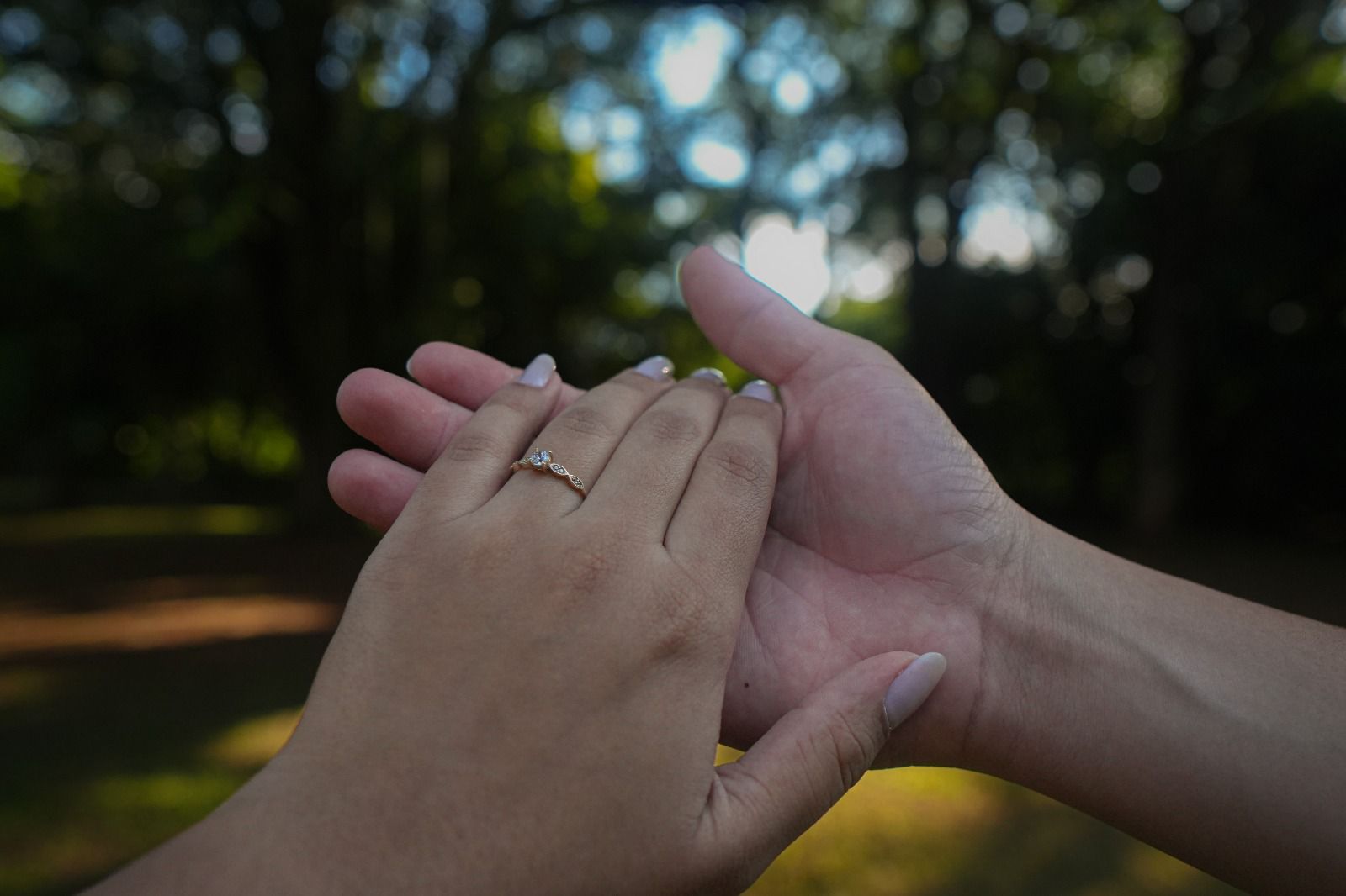 Mãos do casal unidas, com o anel de noivado